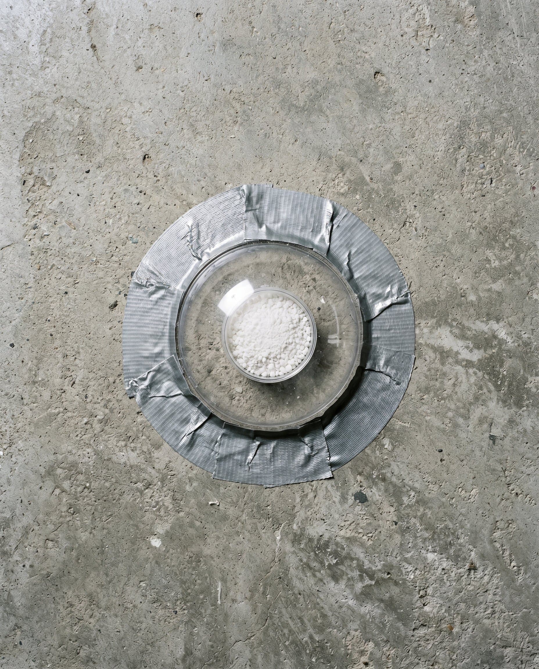 Calcium chloride disc taped to a bare basement slab.