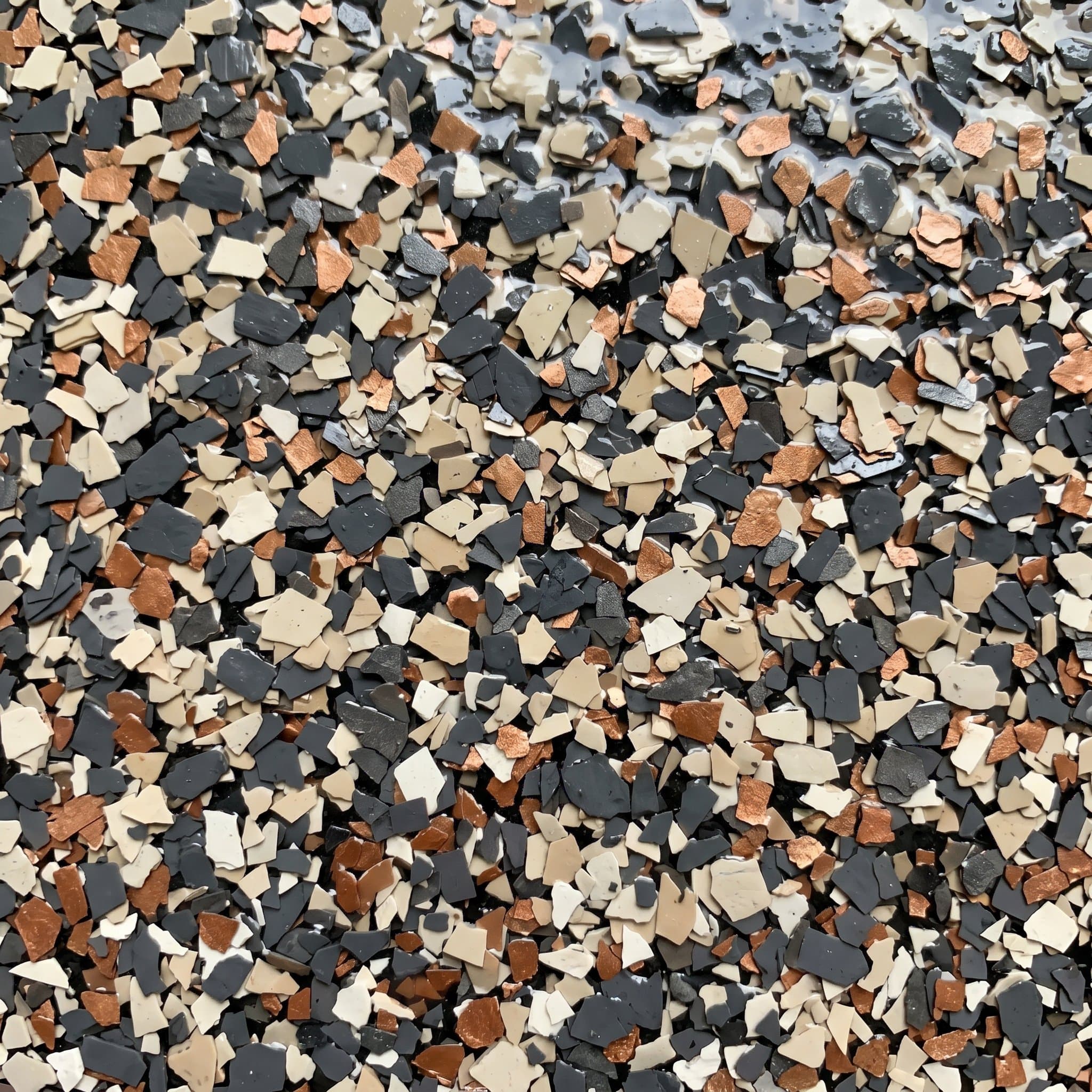 Dense flake field under polyaspartic in charcoal, cream, copper.
