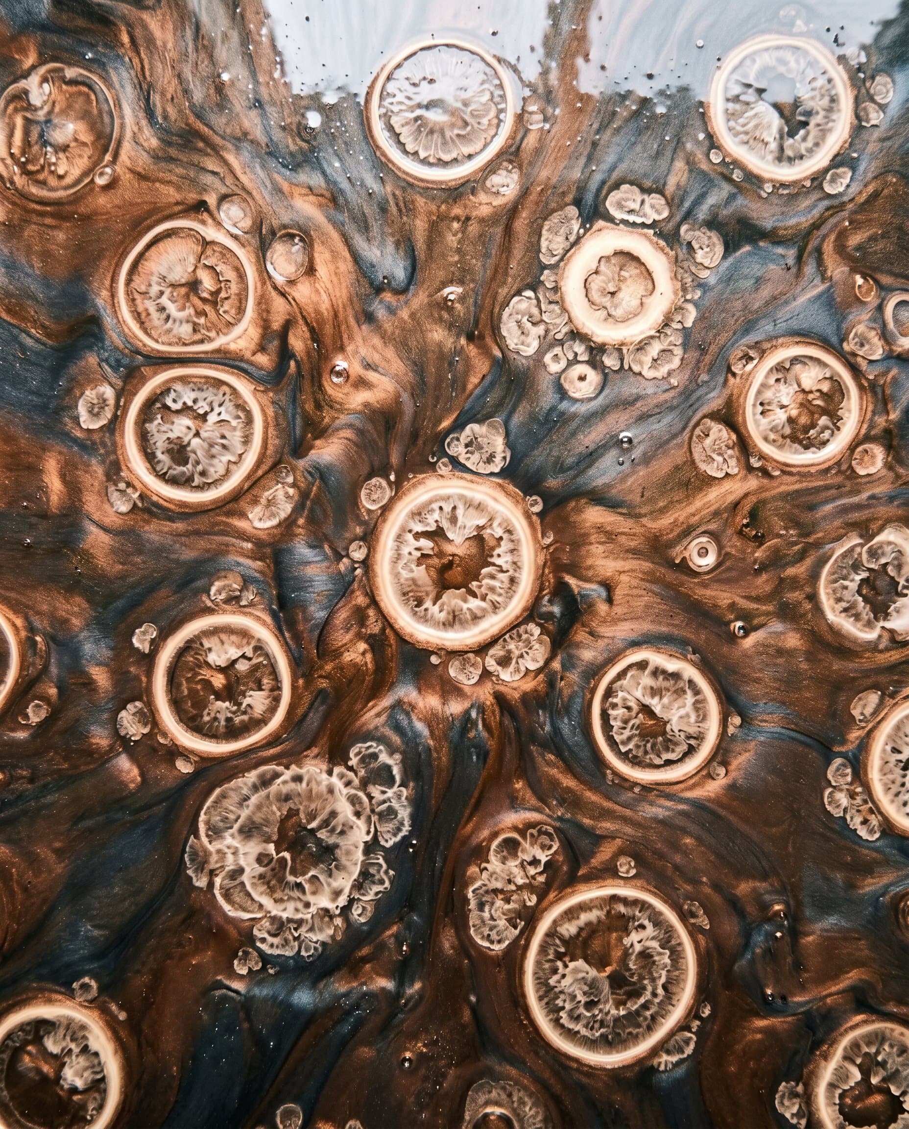 Alcohol drops open circular cell patterns in wet metallic epoxy.